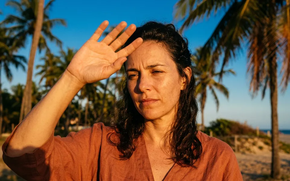 Mulher protegendo o rosto do sol intenso em Fortaleza